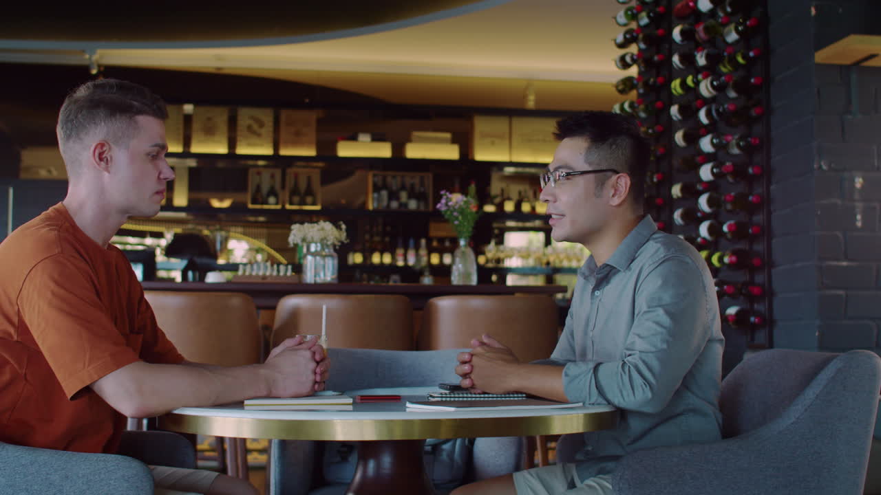 Business Partners Shaking Hands at Cafe Table