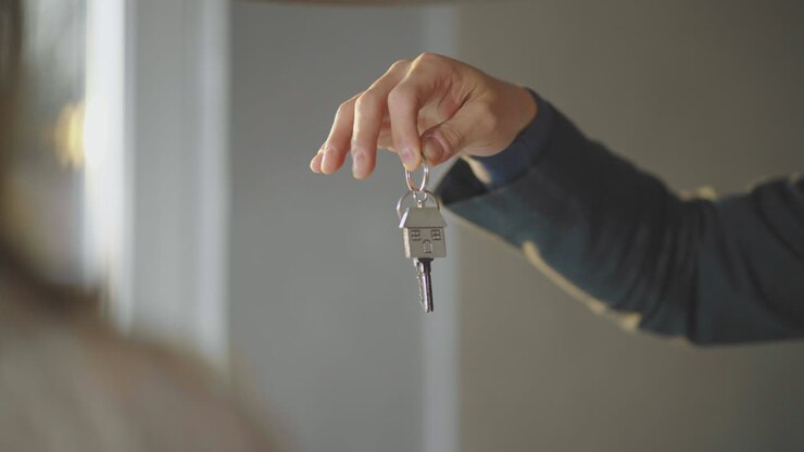 Hand holds key with house shaped keyring