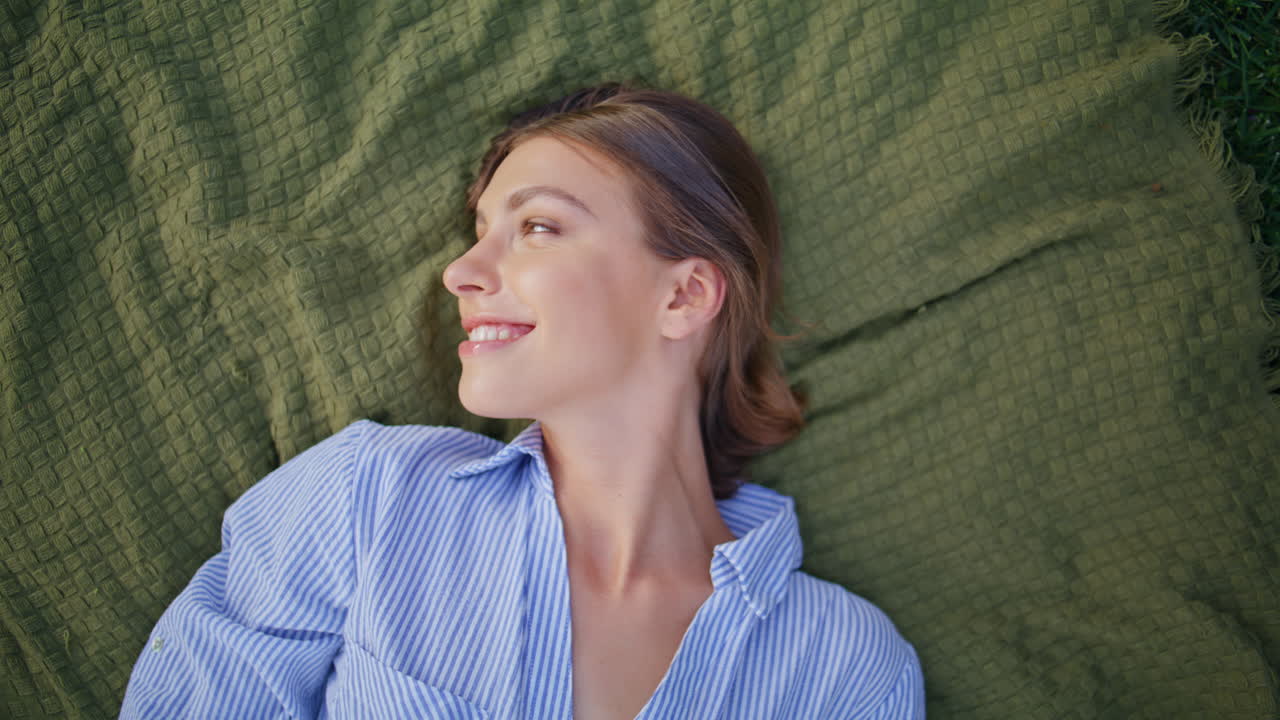 Smiling lady lying nature with cheerful expression closeup. Carefree woman