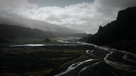 beautiful aerial thor valley, glacial river flowing through black volcanic mountain, thorsmörk landmark cinematic iceland