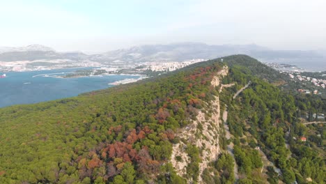 Paisaje-Natural-De-Croacia-En-La-Costa-De-La-Isla-Adriática-Con-Ciudad-En-El-Fondo,-Antena