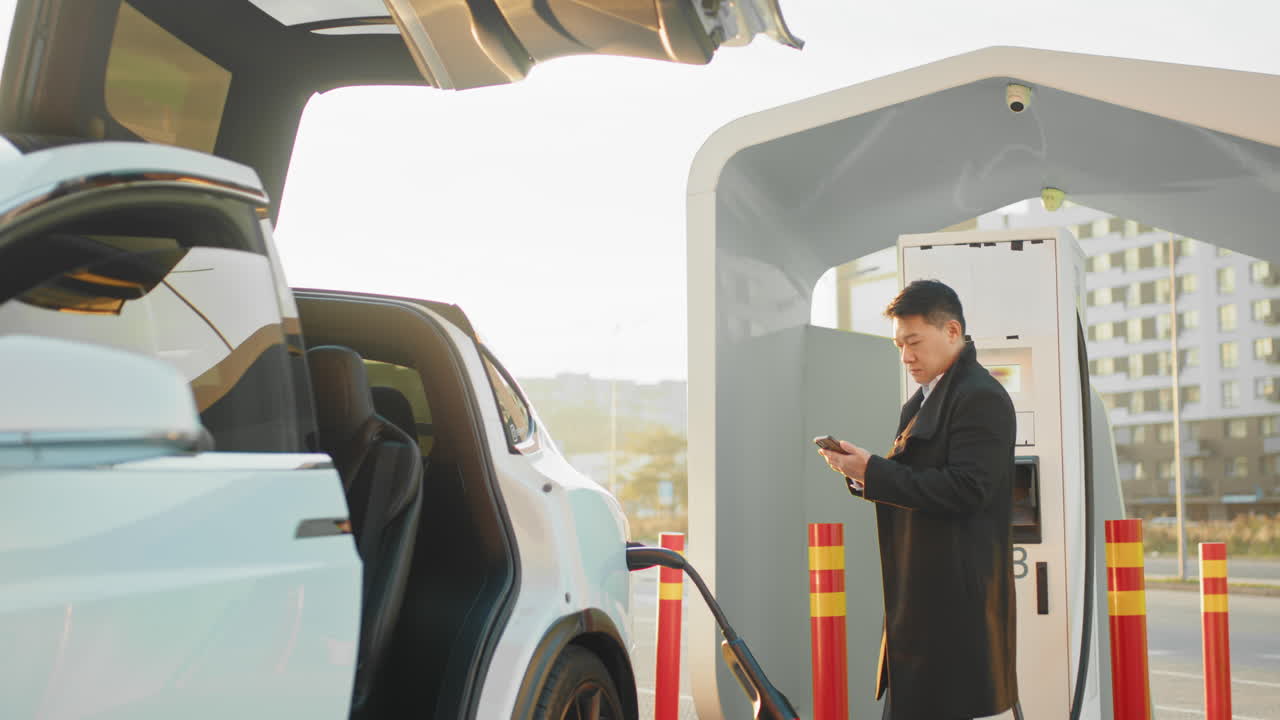 충전소 에서 전기 자동차 를 충전 하는 사람