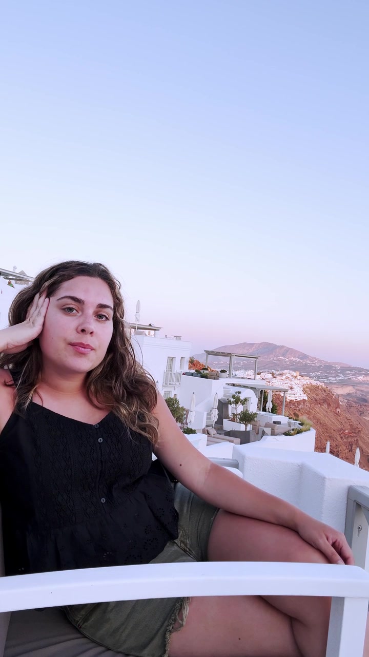 Influencer woman talking to camera in santorini greece