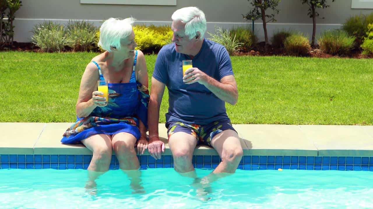 pareja de ancianos interactuando entre sí mientras toman jugo