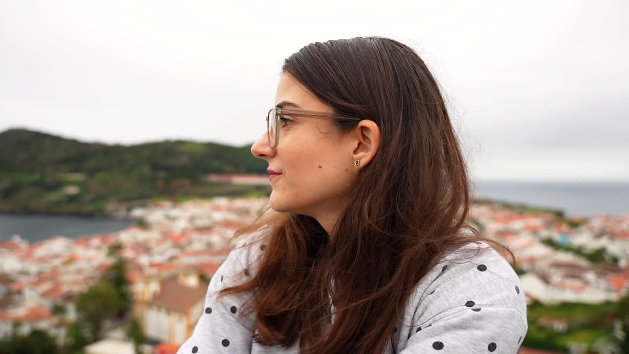 una turista mujer sonríe mientras disfruta de la vista de angra do heroismo