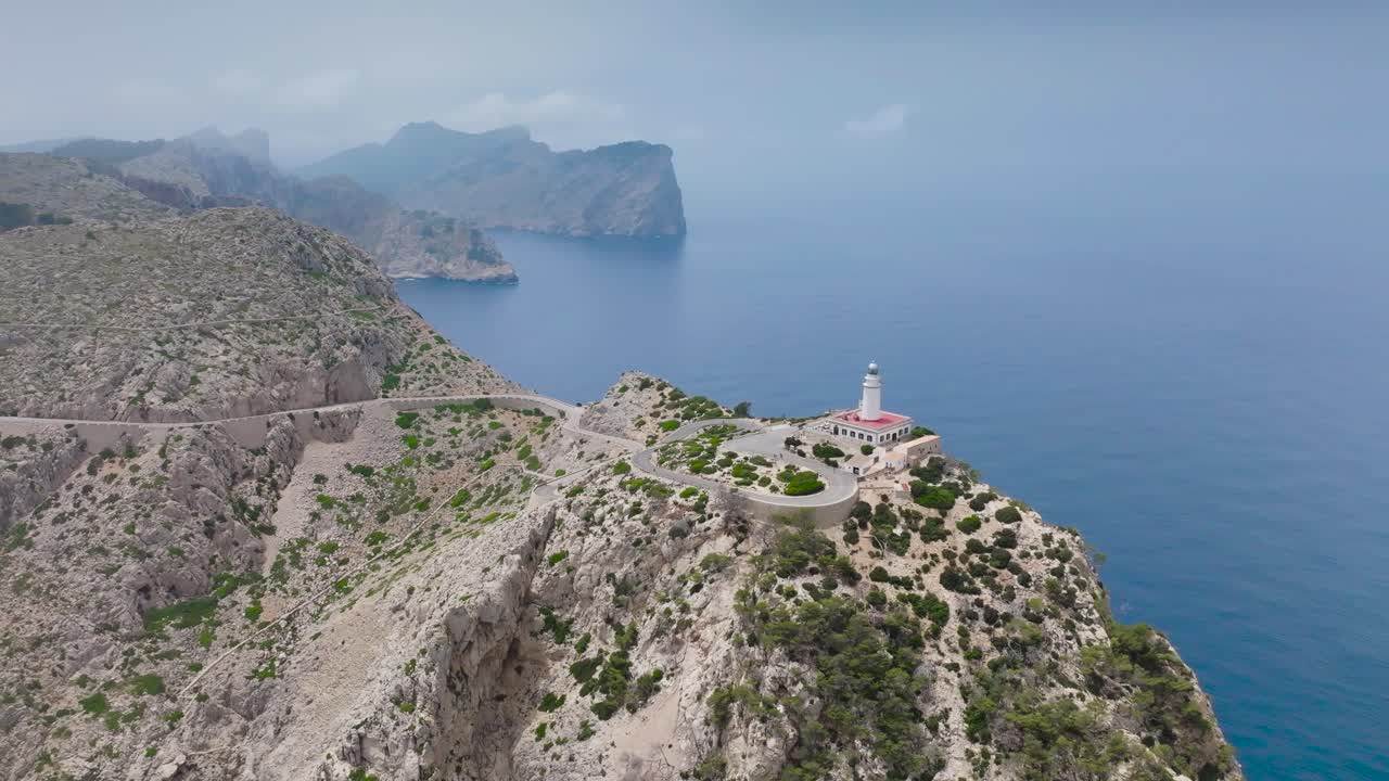 Aerial - lighthouse in scenic mountain environment near cliff edge, Mallorca