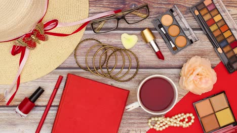 mujer toma de la mano una taza de té, un libro y un lápiz rojo de la mesa con accesorios femeninos elegante y de moda - stop motion