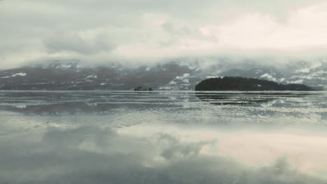 traveling across the frozen lake of haugastol, norway in winter -low aerial