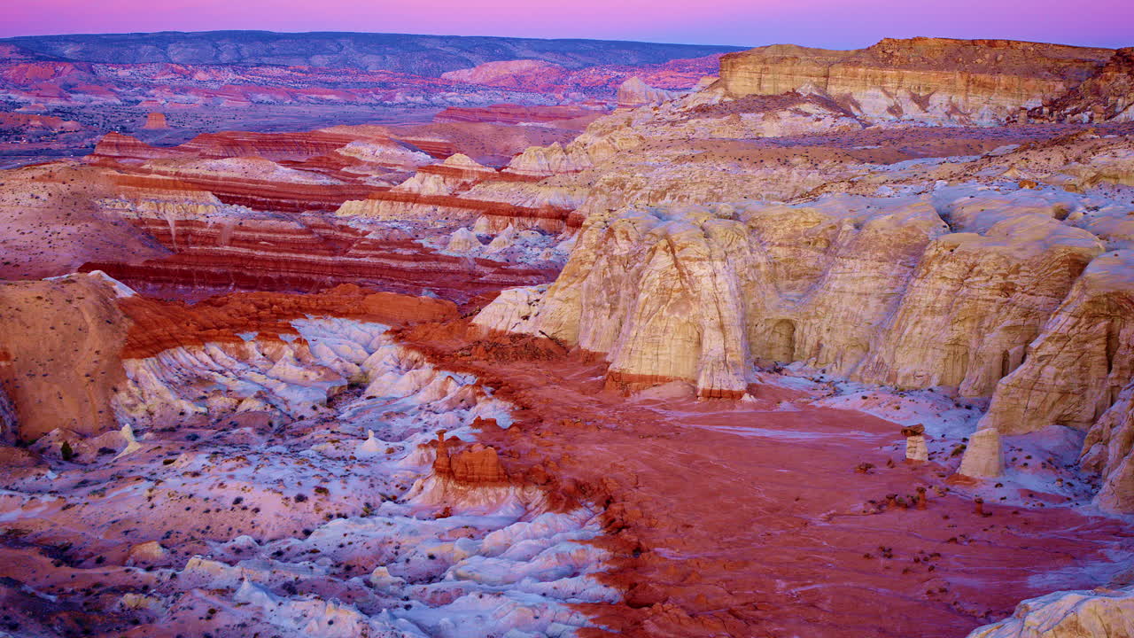 The drone moves slowly across the painted hills and hoodoos, offering a dramatic view near the Utah-Arizona border.