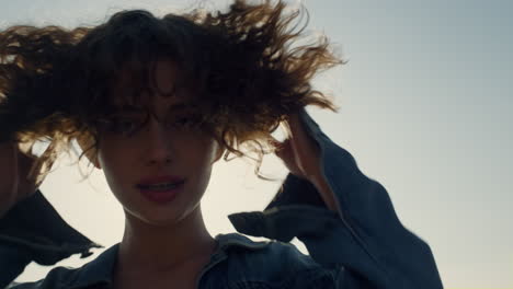 Closeup-glamour-girl-smiling-on-camera.-Happy-woman-touching-curly-hair