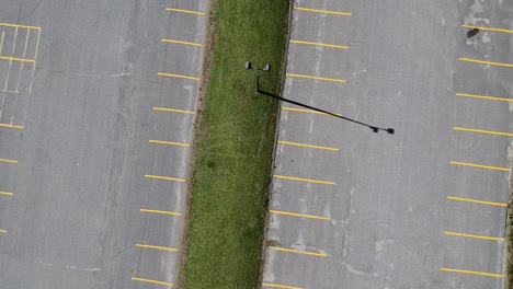 vista aérea de un avión teledirigido de un estacionamiento de automóviles plateado en un estacionamiento vacío afuera durante un día soleado