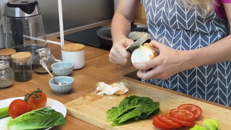 woman peeling and preparing vegetables for a sandwich