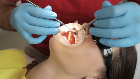 using their hand, eye, and medical equipment, the dentist examines the patient’s teeth, jaw, and mouth during a dental procedure.