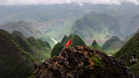 panoramic view of a mountain range in vietnam with a red flag on a peak