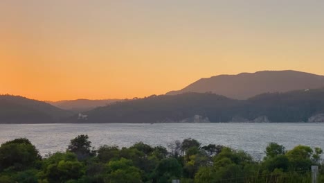 Eine-Ausgezeichnete-Luftaufnahme-Des-Sonnenuntergangs-über-Den-Grünen-Bergen-Und-Einiger-Möwen,-Die-In-Portugal-Fliegen