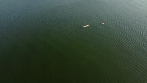 two people driving over a lake with canoes in brandenburg, germany