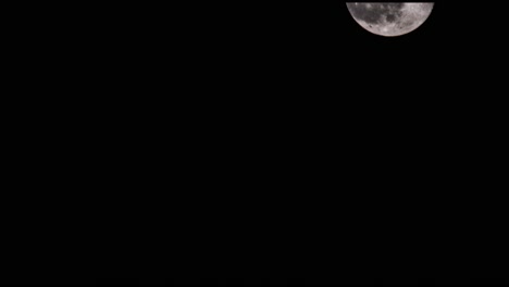 esta es una toma de la luna saliendo desde la parte inferior izquierda de la toma y desapareciendo por la parte superior derecha de la toma