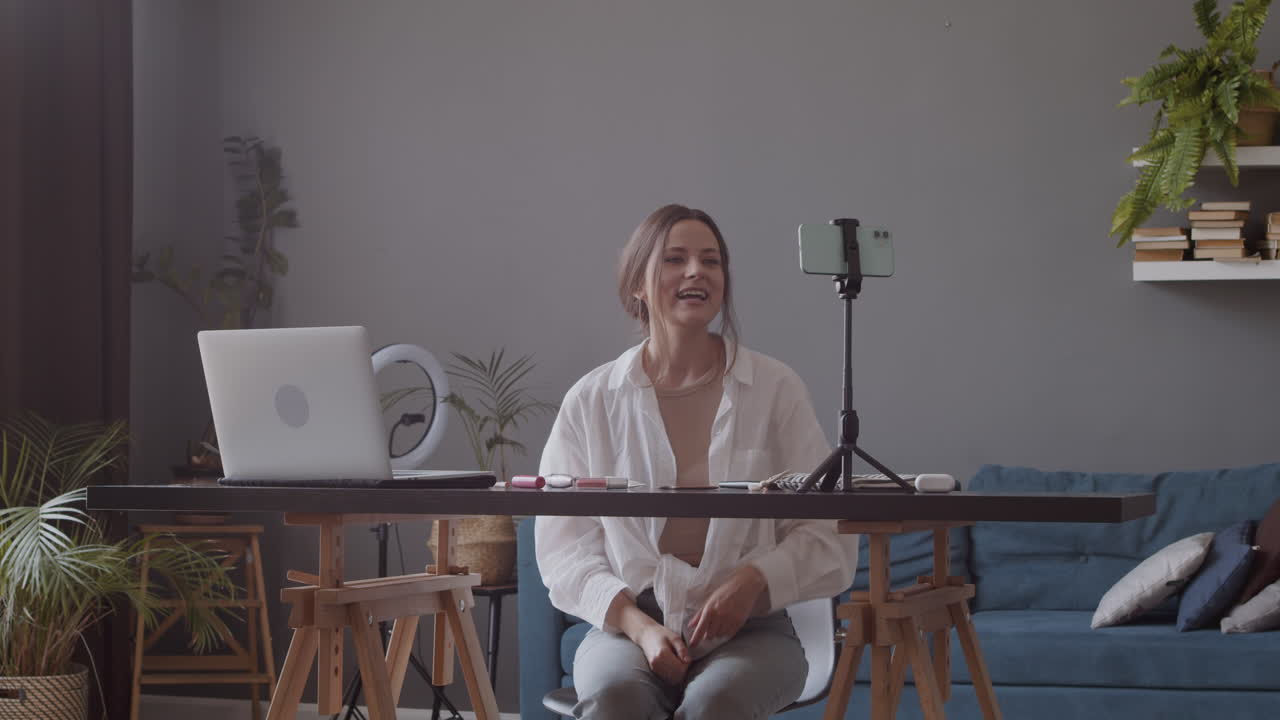 молодая женщина-блогер общается со своими подписчиками через камеру смартфона