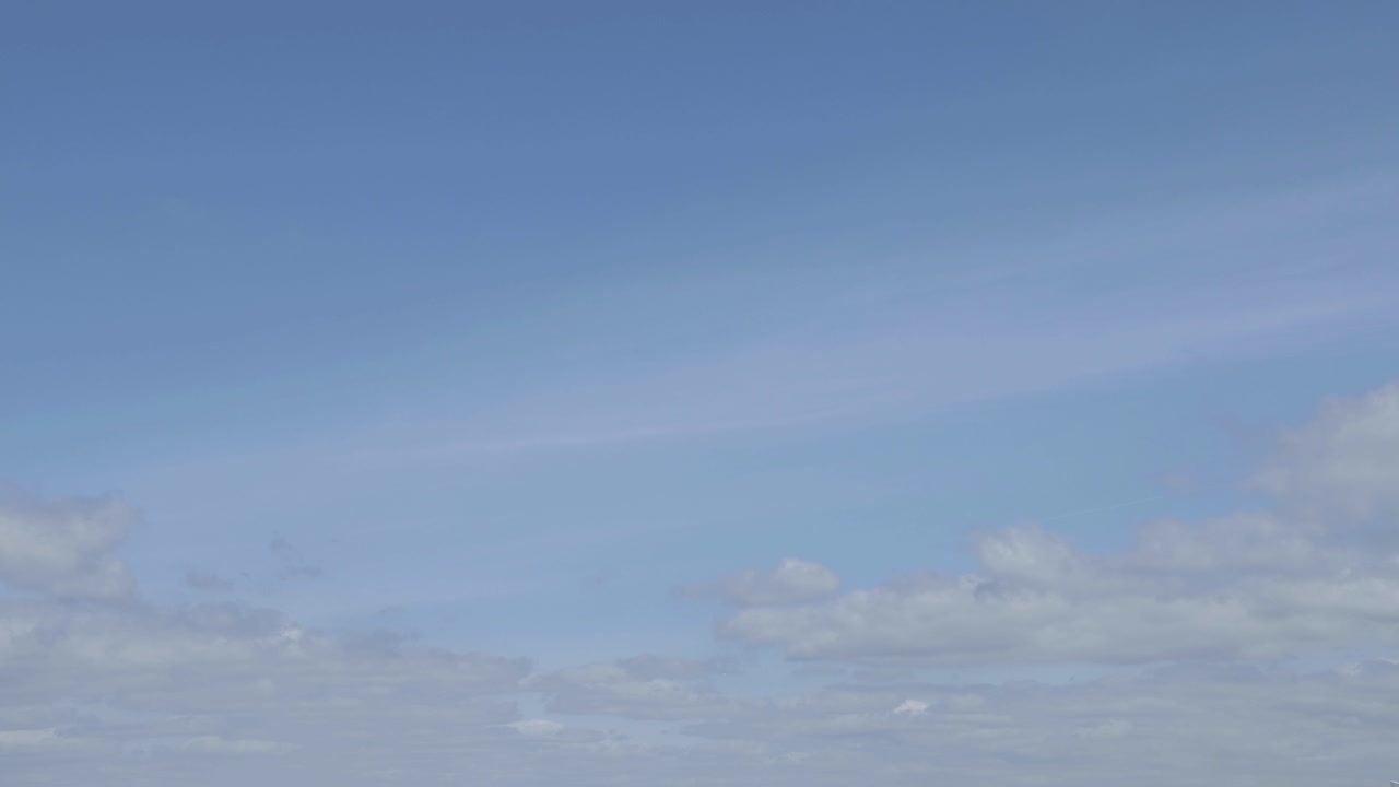 Timelapse of clouds moving and rolling on a blue and sunny sky. Summer time, western Europe