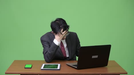 young stressed asian businessman having neck pain