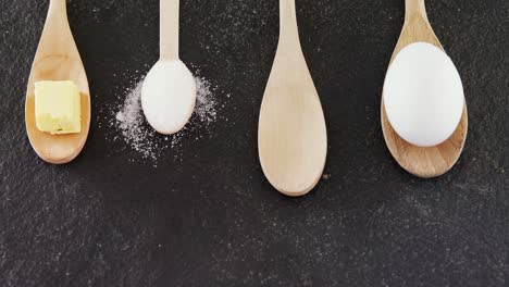 Wooden-spoons-with-egg,-cheese-cube-and-powdered-sugar-4k