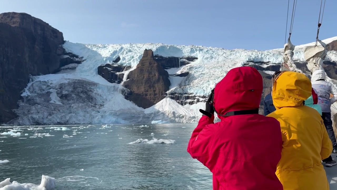 Turistas a bordo del velero disfrutan de la vista del hermoso glaciar Sol. Scoresbysund, Groenlandia.