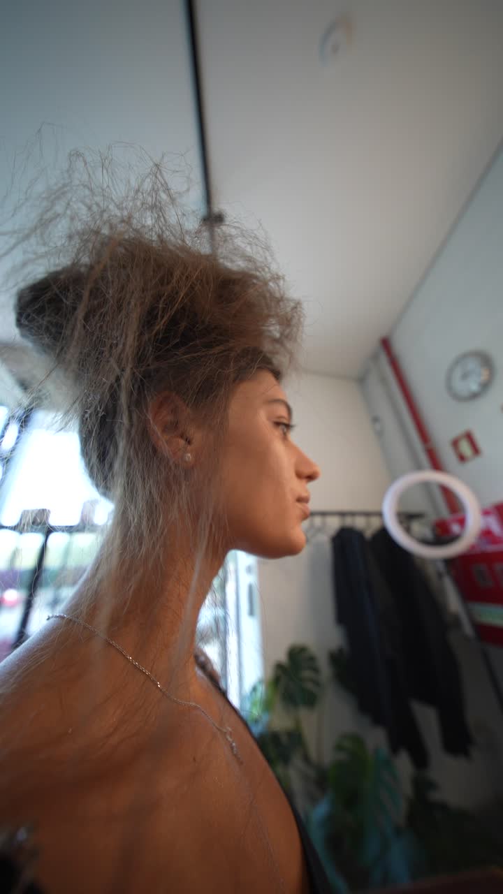 Maquilladora profesional aplicando maquillaje al rostro de una mujer joven