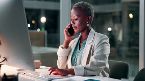 Businesswoman on phone looking at computer screen in the office