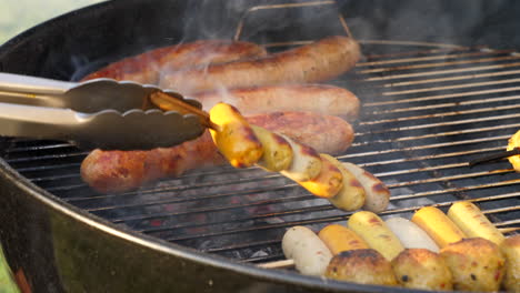 grilling sausages on the barbeque griller with smoke and flame