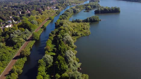 drone-view-of-lake,-forest,-railroad-and-town-of-Norwich,-England
