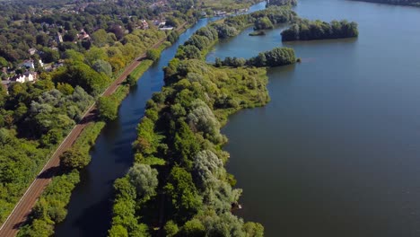 drone view of lake, forest, railroad and town of norwich, england