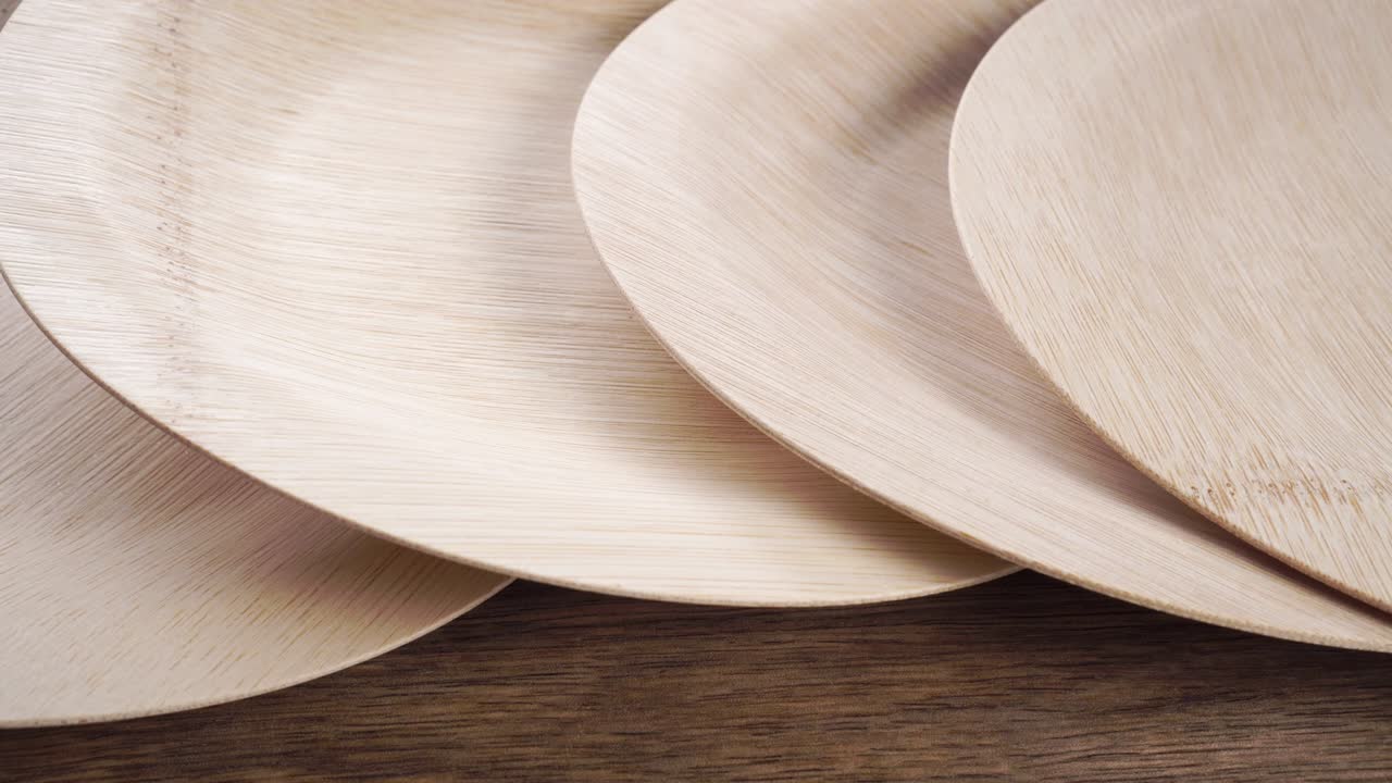 Biodegradable disposable bamboo plate on wooden surface