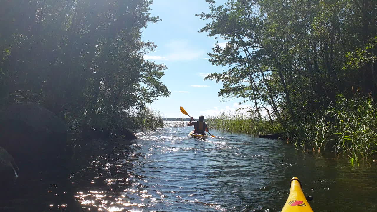 Guy Kayaking in Narrow River, Summer Adventure, POV from Kayak