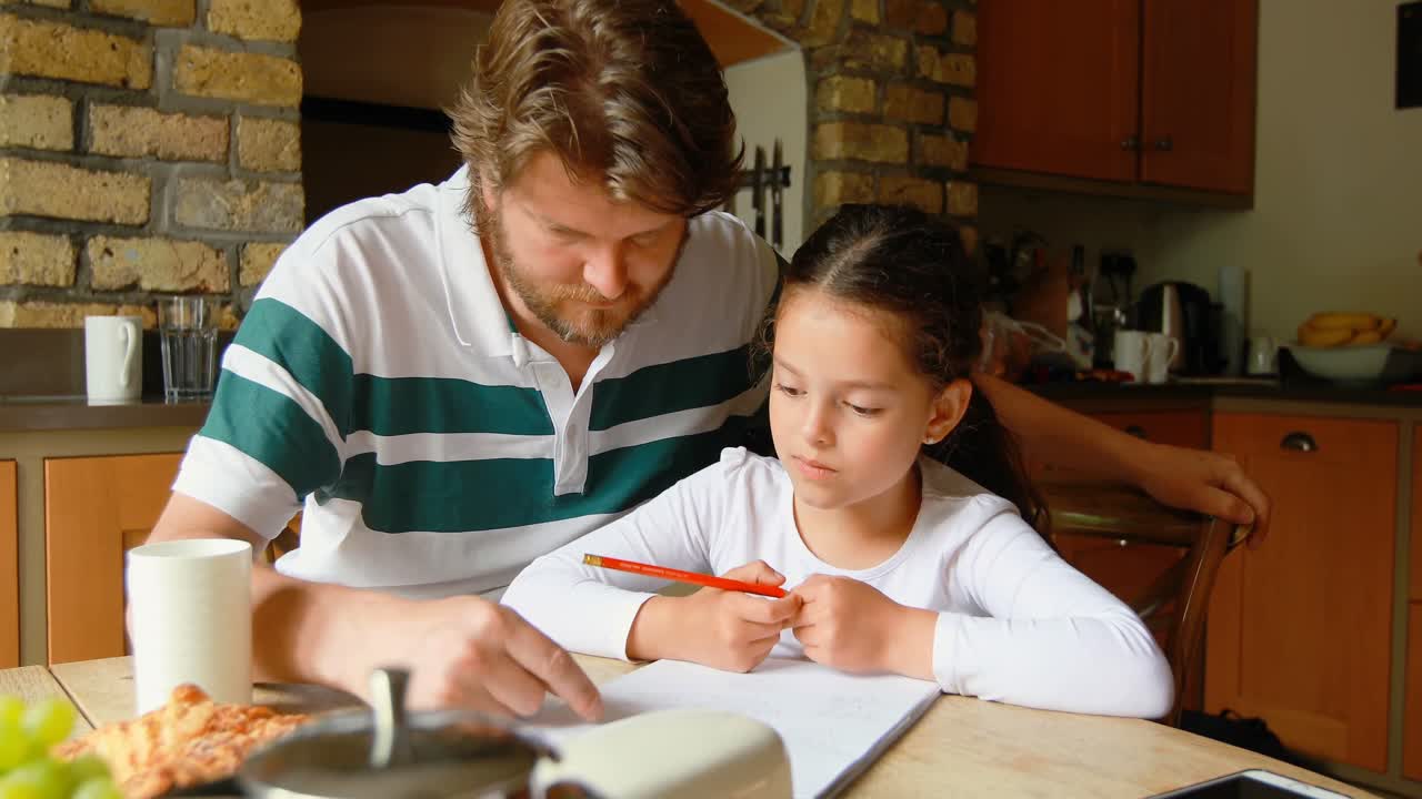 padre ayudando a su hija en los estudios en la cocina 4k