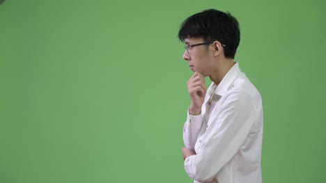 profile view of young asian businessman thinking