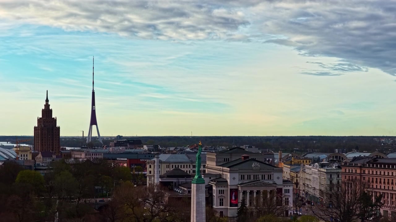 Panorama urbano con il Monumento alla Libertà e le guglie delle chiese a Riga, Lettonia, sotto una luce diurna soffusa.