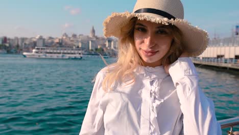 beautiful girl stands near bosphorus with view of galata in istanbul,turkey
