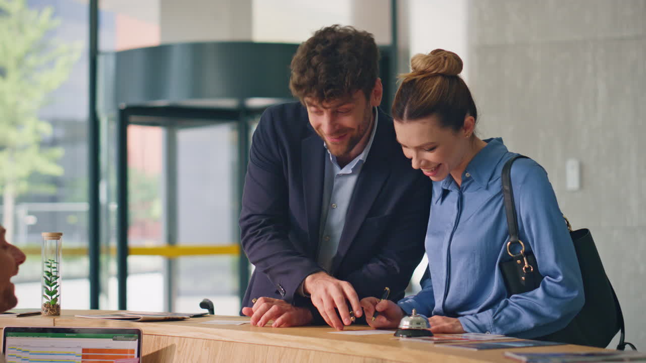 pareja llenando formularios de hotel en el mostrador de primer plano. huéspedes amigables se registran juntos