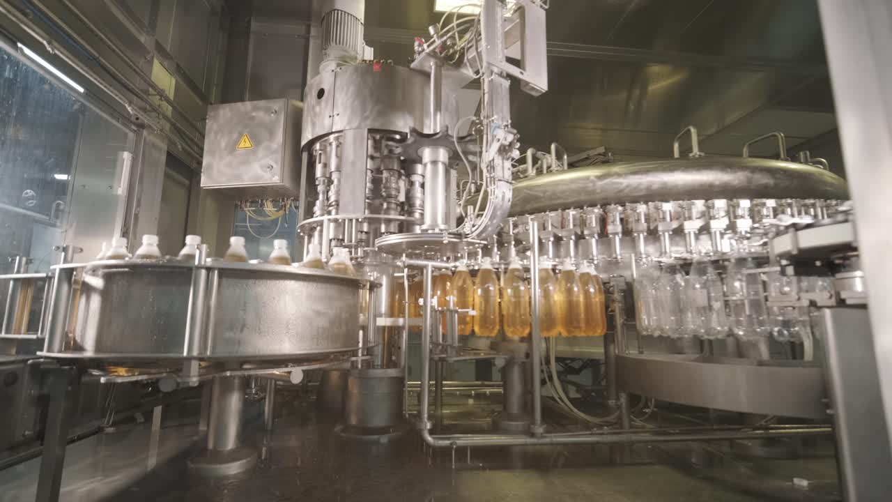 Automatic filling machine pours water into plastic PET bottles at modern beverage plant