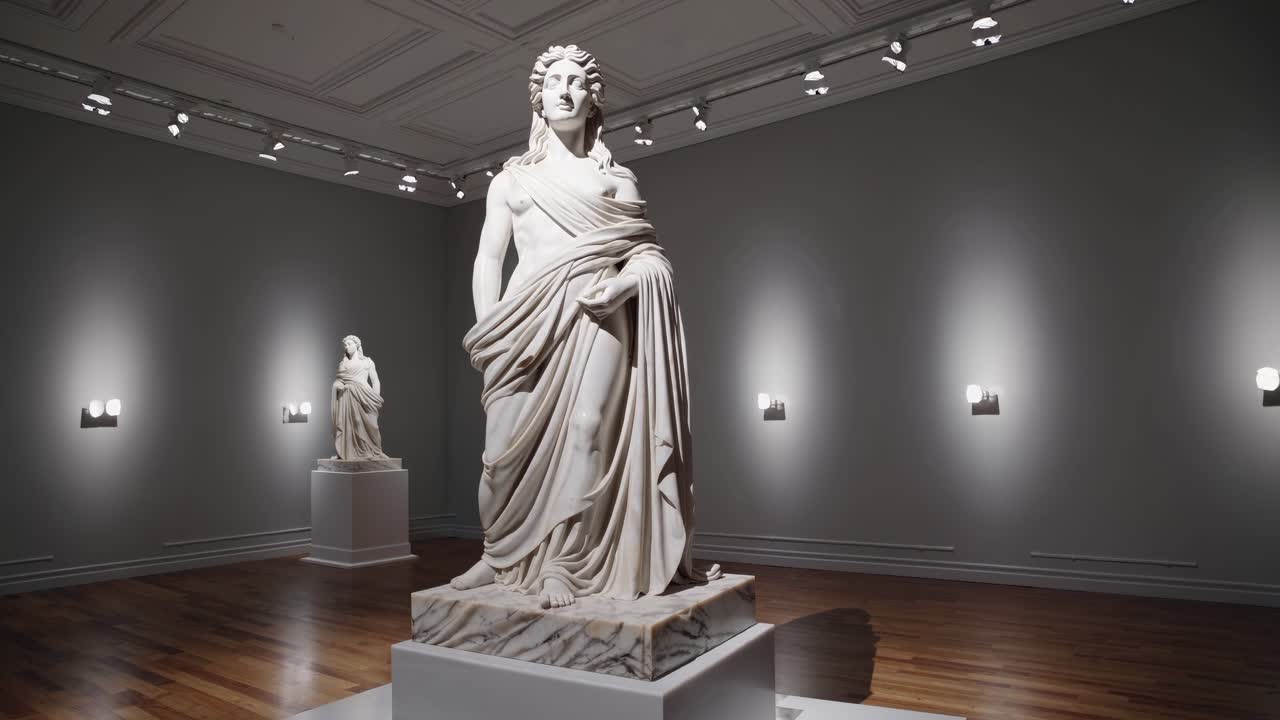 Video di sculture classiche in una galleria, ripreso da un angolo basso, che ne mette in risalto la grandiosità