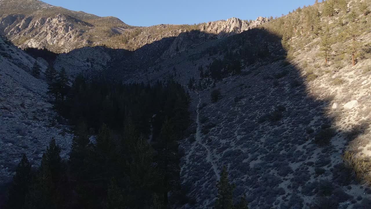 vista aérea de un valle con pinos rodeado de montañas en el este de sierra nevada en california, donde se encuentran el bosque nacional inyo, los grandes lagos de pino, el circuito de senderismo y el parque nacional kings canyon