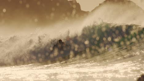 golden glassy wave with surfer kicking back and spraying out across water at sunset, silhouette
