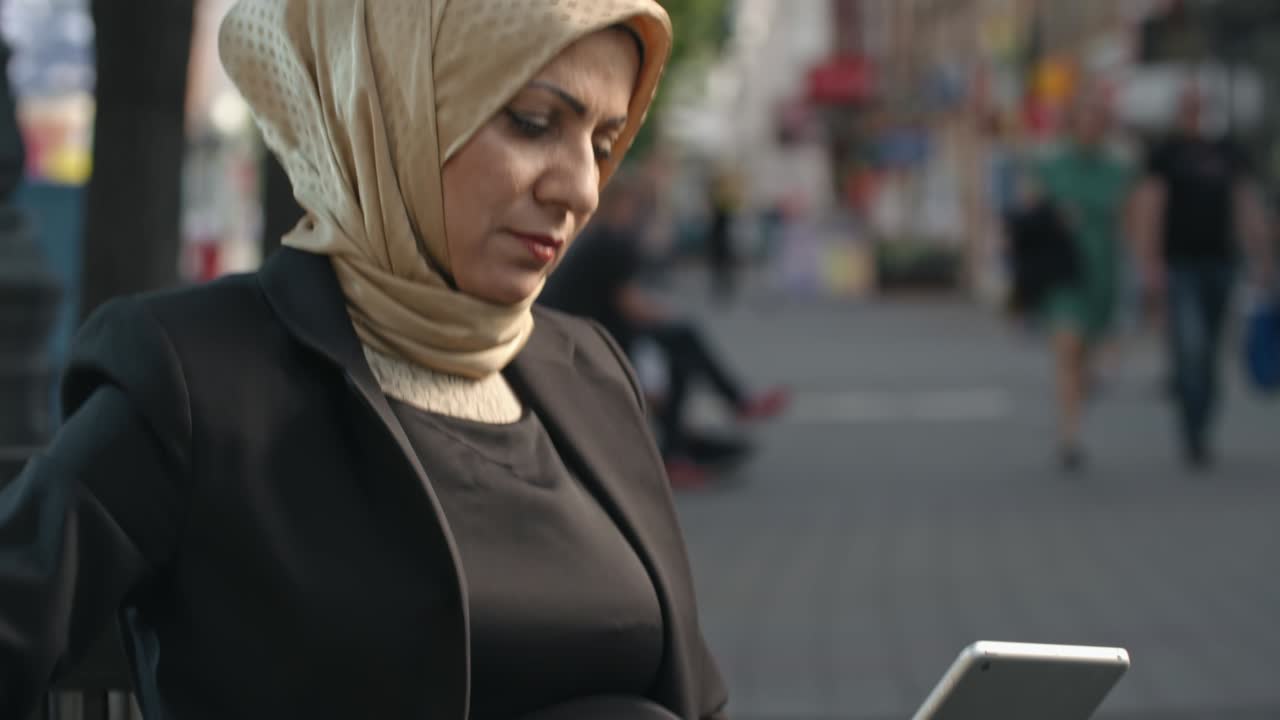 태블릿을 사용하고 커피를 마시는 중동 여성