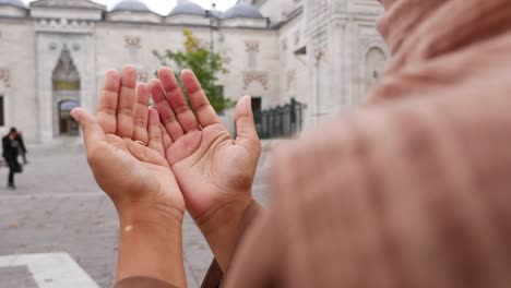 a person praying in front of a mosque