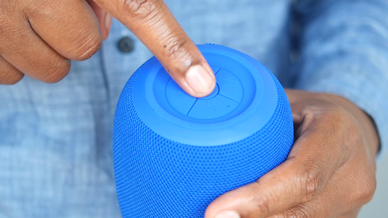 Person using a blue portable speaker