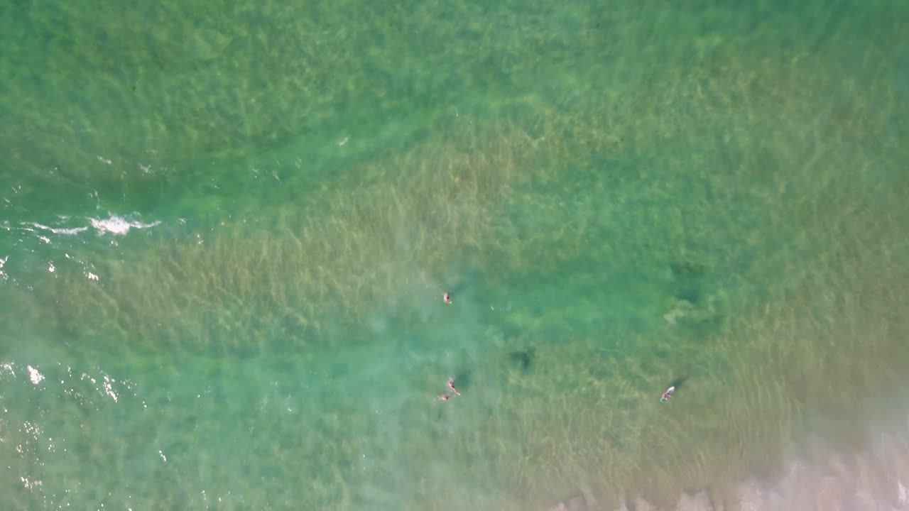 위에서 내려오는 공중 풍경은 바론 만의 고 평화로운 바다 파도 위로 빠르게 상승하여 물의 리적 인 움직임과 평온한 아름다움을 포착합니다.