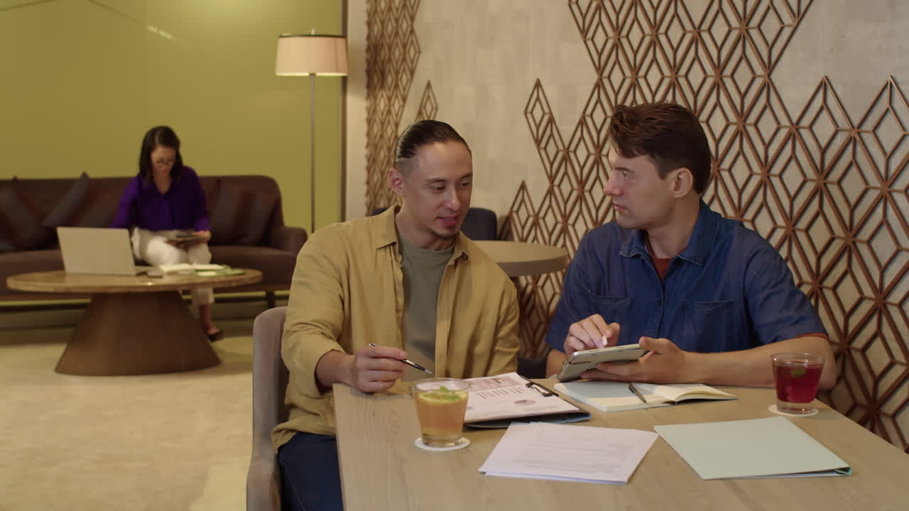 Business Colleagues Gathering at Table to Discuss Project Details