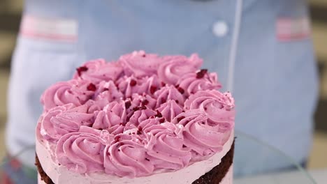 chef decorating a raspberry pink cake