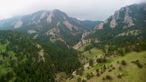 aerial ascending view of flatirons landscape valley and hiking trails, boulder, colorado