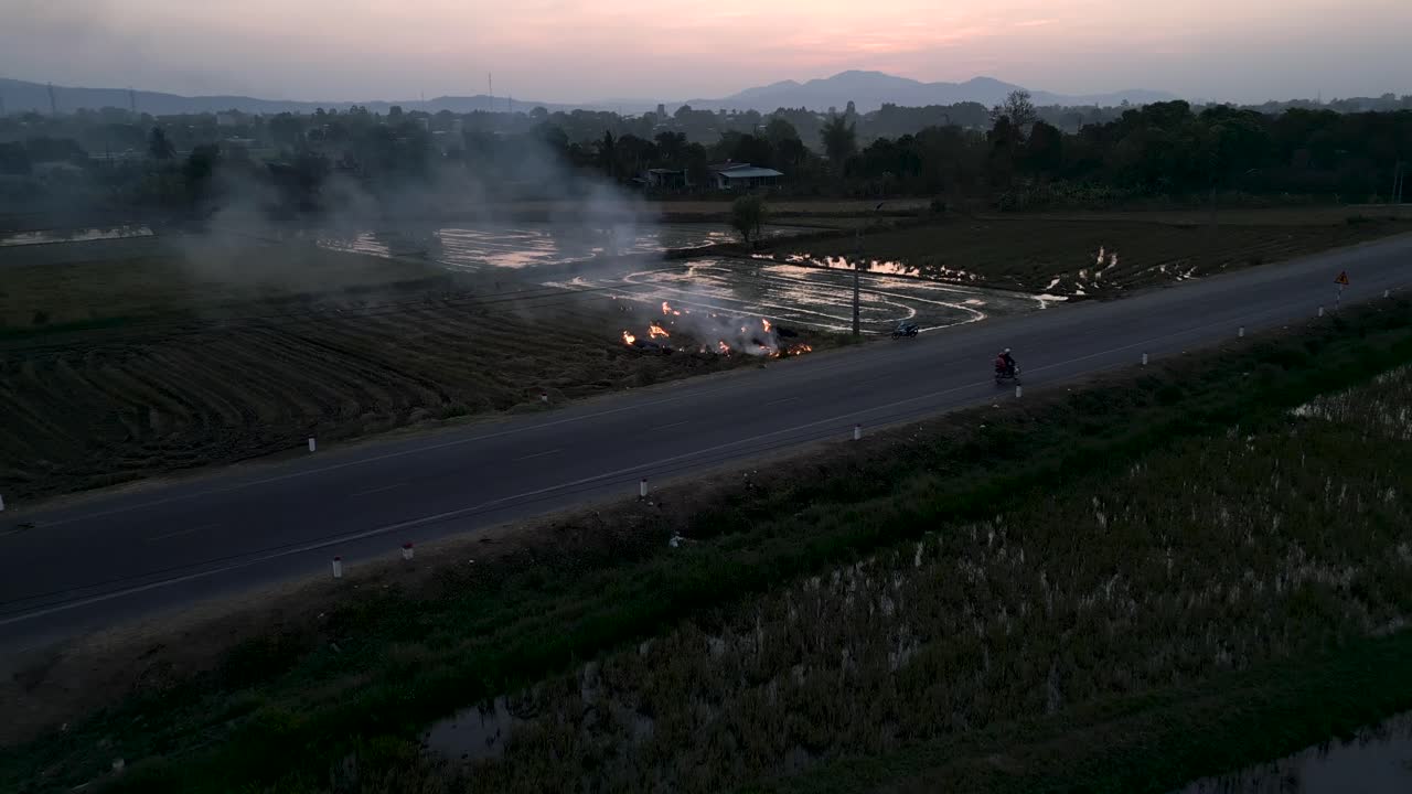 Rice Paddy Fields with Burning Vegetation at Sunset/Sunrise